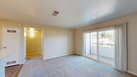 Located at 3825 Little Rock Drive in Antelope, California, this single-floor, one-bedroom, one-bathroom home offers a generous and well-organized layout. The combined kitchen and living room serves as the heart of the home, featuring light wood-style flooring, white cabinetry, white appliances including a range and refrigerator, and ample counter space. A ceiling fan overhead adds comfort to the living area, which also benefits from a sliding glass door that opens to an outdoor patio, filling the room with natural light and providing neighborhood views. The bedroom is a comfortable retreat finished with plush carpeting, a window with exterior views, and direct access to a dedicated closet with built-in shelving. The full bathroom includes a combined tub and shower unit with clean white surround, wood-style flooring, and brushed nickel fixtures. A dedicated laundry area accommodates a full-sized side-by-side washer and dryer. A hallway connects the rooms, contributing to the home's efficient and cohesive flow. Neutral warm-toned walls throughout the space create a clean, versatile backdrop. The overall ambiance is bright, functional, and move-in ready.