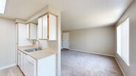 This single-floor residence offers a practical and well-organized layout with 2 bedrooms and 2 bathrooms. The living room is bright and welcoming, featuring soft carpeting, a ceiling fan, and two large windows with vertical blinds that allow generous natural light and outdoor views. The combined kitchen and dining area is efficiently designed with a galley-style layout, featuring white cabinetry with gold-toned accents, light wood-look flooring, a skylight, white appliances including an electric range and refrigerator, and a stainless steel sink with ample counter space on both sides. The open-concept connection between the kitchen and dining/living area promotes a seamless flow throughout the common spaces. The primary bedroom is generously sized, offering plush carpet, a sliding glass door leading to a private balcony, and direct access to one of the two bathrooms. The second bedroom also features carpet flooring and a window that brings in natural light. Both bathrooms are finished with light wood-look flooring, vanities with under-counter storage, and neutral tones throughout. A dedicated closet provides additional storage. The overall interior palette of warm beige and white tones gives the space a clean, neutral, and move-in-ready ambiance.