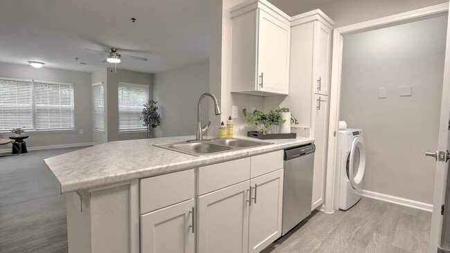 Kitchens designed for entertaining with luxury countertops and bar seating. - The Grays at Old Town