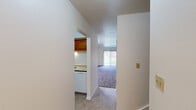 This two-story home offers a practical and well-organized layout, with living space divided evenly between its two floors. The main level features a living room bathed in natural light from a large sliding glass door, providing an open and airy atmosphere. Tile flooring flows through the entryway and into the kitchen, which is equipped with warm-toned oak cabinetry, a smooth-top electric range, a refrigerator, and a window that brings in additional natural light. The kitchen connects seamlessly to the living area via a hallway, creating an efficient flow throughout the main floor.

The bedrooms are carpeted throughout, offering a soft, comfortable underfoot feel. The spacious primary bedroom provides ample room and includes a closet with bifold doors. The two additional bedrooms are well-sized and bright, each with neutral walls and carpet flooring. Both bathrooms are finished with tile flooring, white vanity cabinetry, and a tub-shower combination with white tile surrounds.

Throughout the home, clean white walls, consistent trim details, and neutral color choices create a cohesive and move-in-ready aesthetic. Two staircases connect the floors, enhancing accessibility and circulation within the home. Overall, the space offers a straightforward, functional design suitable for a variety of living arrangements.