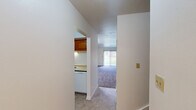 This two-story home offers a practical and well-organized layout, with living space divided evenly between its two floors. The main level features a living room bathed in natural light from a large sliding glass door, providing an open and airy atmosphere. Tile flooring flows through the entryway and into the kitchen, which is equipped with warm-toned oak cabinetry, a smooth-top electric range, a refrigerator, and a window that brings in additional natural light. The kitchen connects seamlessly to the living area via a hallway, creating an efficient flow throughout the main floor.

The bedrooms are carpeted throughout, offering a soft, comfortable underfoot feel. The spacious primary bedroom provides ample room and includes a closet with bifold doors. The two additional bedrooms are well-sized and bright, each with neutral walls and carpet flooring. Both bathrooms are finished with tile flooring, white vanity cabinetry, and a tub-shower combination with white tile surrounds.

Throughout the home, clean white walls, consistent trim details, and neutral color choices create a cohesive and move-in-ready aesthetic. Two staircases connect the floors, enhancing accessibility and circulation within the home. Overall, the space offers a straightforward, functional design suitable for a variety of living arrangements.