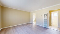 Located at 22027 S Vermont Ave in Torrance, CA, this single-floor, one-bedroom, one-bathroom unit offers an efficiently designed layout. The spacious bedroom is a standout feature, finished with light-toned hardwood-style flooring, warm yellow-beige walls, and elegant crown molding throughout. Gold-framed mirrored sliding closet doors add a reflective touch, enhancing the sense of openness. A window allows natural light to fill the room, creating a bright and airy atmosphere.

The kitchen is thoughtfully appointed with white cabinetry, granite-look countertops, a double stainless steel sink, and a gas range. A window above the sink brings in natural light and provides an outdoor view, while warm tile flooring completes the space.

The bathroom is clean and functional, featuring neutral tile flooring and a window that provides both ventilation and natural light. A hallway connects the rooms, contributing to a smooth and logical flow throughout the unit.

Crown molding details, consistent flooring, and a cohesive warm color palette give the entire space a polished and well-maintained character. The layout, as seen in the 3D model, maximizes every square foot, making this a practical and comfortable Torrance residence.
