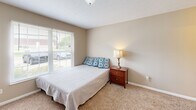 Located at 1601 E Florida Ave in Urbana, IL, this 2-bedroom, 2-bathroom unit offers a practical and comfortable single-floor layout designed to maximize every square foot. The kitchen is a standout feature, equipped with light wood cabinetry, black appliances including a refrigerator, range, and microwave, and a granite-style peninsula with bar seating — ideal for casual dining or entertaining. Wood-look flooring runs through the main living and kitchen areas, adding warmth and durability. Both bedrooms are carpeted and offer a quiet, cozy atmosphere. The primary bedroom is generously sized, featuring multiple windows that bring in abundant natural light and views of the surrounding greenery. Additional storage is provided via a closet with louvered doors visible near the kitchen. Each bathroom is well-appointed with a tub-shower combination, single vanity with wood cabinetry, and tile flooring. The neutral, warm color palette used throughout the unit creates a cohesive and inviting ambiance. The overall layout, as seen in the floorplan overview, is efficiently organized with clear separation between the living, kitchen, and bedroom areas, making it a functional and comfortable residence.