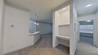 This contemporary apartment showcases a thoughtful design with a focus on functionality and style. The open floor plan seamlessly connects the kitchen, dining, and living areas, creating a spacious feel. The kitchen boasts white cabinetry, stainless steel appliances, and a central island with pendant lighting. Bedrooms feature plush carpeting and large windows, while bathrooms offer modern fixtures and tiled surfaces. Crown molding, ceiling fans, and recessed lighting add refined touches throughout. A built-in desk area and ample storage solutions enhance the apartment's practicality. The neutral color scheme and abundance of natural light contribute to a fresh, airy ambiance.