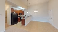 Located at 175 N Woods Dr in Fountain Inn, South Carolina, this single-story residence offers a well-designed, open-concept layout that maximizes both functionality and comfort. The living area features vaulted ceilings with a ceiling fan and a seamless transition between tile flooring near the entry and plush carpeting throughout the main living space, creating a warm and inviting atmosphere.

The kitchen is a functional centerpiece, outfitted with rich cherry-toned cabinetry, granite countertops, and black appliances including a refrigerator, range, and microwave. A raised breakfast bar with pendant lighting above serves as a natural divider between the kitchen and the adjacent dining area, which is further illuminated by an elegant chandelier. Crown molding and wainscoting add refined architectural detail to the dining space.

The bedrooms are carpeted and well-lit, with multiple windows fitted with horizontal blinds that provide views of the surrounding neighborhood. One room features corner windows for enhanced natural light. Closets include walk-in storage with wire shelving systems for organized storage.

The bathrooms are finished with granite-topped vanities set in rich cabinetry, undermount sinks, and tile flooring, reflecting a consistent attention to quality throughout the home.