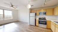 Located at 600 N Stonewall Ave in Oklahoma City, Oklahoma, this two-bedroom, one-bathroom unit offers a functional and efficiently laid-out single-floor living space. The open-concept kitchen flows seamlessly into the living area and is outfitted with light maple cabinetry, stainless steel appliances including a range, microwave, dishwasher, and refrigerator, as well as a double-basin sink and track lighting overhead. Wood-look flooring runs throughout the kitchen and living area, adding warmth and easy maintenance. Both bedrooms are carpeted, providing a comfortable underfoot feel, and are well-lit with natural light streaming through windows. The primary bedroom includes a ceiling fan and a dedicated walk-in closet with built-in shelving and hanging rods, offering ample storage. The second bedroom is cozy and bright, also featuring carpet flooring. The full bathroom is finished with tile flooring, a light wood vanity with a single sink, and a full tub-shower combination. Crisp white walls and neutral tones throughout create a clean, move-in-ready atmosphere suited for comfortable everyday living in Oklahoma City.