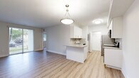 Located at 4150 Davie Road Ext in Hollywood, FL, this single-story residence offers a clean, modern aesthetic with a bright and open floor plan. Light wood-style flooring flows seamlessly throughout the entire space, creating a cohesive and contemporary feel.

The open-concept living and dining area is spacious and filled with natural light, connecting effortlessly to the kitchen via a peninsula counter with a pendant light fixture overhead. The well-appointed kitchen features white shaker-style cabinetry, granite countertops, a subway tile backsplash, and a full suite of stainless steel appliances including a refrigerator, range, microwave, and dishwasher.

The bedroom is generously sized, featuring two windows that invite natural light and garden views, a ceiling fan, and access to a walk-in closet. An additional louvered closet provides extra storage along the hallway. Each bathroom is finished with granite vanity countertops, white cabinetry, and a tub/shower combination surrounded by neutral tile. The primary bath includes a dedicated walk-in closet and is accessible directly from the bedroom. Throughout the space, a consistent palette of white walls and warm flooring tones creates a calm, move-in-ready ambiance.
