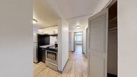 This one-bedroom, one-bathroom unit at 1255 S Bellaire St in Denver, Colorado offers a well-organized and functional layout across a single floor. Light wood-style flooring runs throughout, creating a cohesive and clean aesthetic in every room.

The open kitchen and living area form the heart of the unit. The kitchen is equipped with stainless steel appliances, including a range and refrigerator, complemented by two-tone cabinetry — dark lower cabinets paired with white uppers — and granite-style countertops. A hallway connects the kitchen to the rest of the unit, with a louvered closet door providing additional storage near the entry.

The living room is bright and open, featuring a classic brick fireplace as a focal point and sliding glass doors that allow natural light to fill the space and provide access to an outdoor patio area.

The bedroom is generously proportioned and includes two full-width louvered bifold closets, offering ample storage. A window brings in additional natural light.

The bathroom is well-appointed with a long granite-style vanity countertop, dark cabinetry, a large mirror, tiled walls, and a full bathtub-shower combination. Clean white walls and wood-style flooring carry the consistent design throughout.

Overall, the unit presents a neutral, move-in-ready palette with practical finishes throughout.