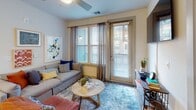Located at 12310 Moores Lake Road in Chester, Virginia, this single-floor residence offers a thoughtfully designed layout with contemporary finishes throughout. The living area is bright and welcoming, featuring wood-style flooring, a ceiling fan, and large windows paired with a glass-panel door that provides access to an outdoor space, allowing natural light to fill the room.

The kitchen is a functional centerpiece, outfitted with white shaker cabinetry, dark granite countertops, stainless steel appliances including a refrigerator, range, and microwave, and a peninsula with bar seating illuminated by pendant lighting. Wood-style flooring continues seamlessly from the kitchen into the adjacent areas.

Two bedrooms offer comfortable retreats, each with wood-style flooring, ceiling fans, and windows dressed with blinds and curtains. The primary bedroom includes a walk-in closet equipped with multi-tiered wire shelving for organized storage. Both bathrooms feature white cabinetry, granite countertops, subway-tiled tub-shower combinations, and brushed nickel fixtures.

Overall, the space presents a clean, modern aesthetic with consistent finishes, practical storage solutions, and a well-connected floor plan suited for everyday living.