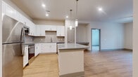Located at 2272 Parkstone Dr in Indian Land, SC, this well-appointed 2-bedroom, 2-bathroom single-floor home offers a thoughtfully designed layout with modern finishes throughout. The open-concept kitchen and living area serve as the heart of the home, centered around a granite-topped island with pendant lighting above. The kitchen is equipped with stainless steel appliances — including a refrigerator, range, microwave, and dishwasher — paired with crisp white shaker cabinetry and a tile backsplash. Light hardwood flooring flows seamlessly through the main living areas, enhancing the bright and airy atmosphere created by recessed lighting throughout. The living room provides an open, versatile space with clean white walls and easy access to the rest of the home. Both bedrooms are carpeted for comfort, each featuring a ceiling fan and windows that bring in natural light with views of the surrounding community. The primary bedroom is generously sized and connects to a private en-suite bathroom with granite countertops, white cabinetry, and a walk-in closet with built-in shelving. The second bathroom mirrors the same refined finishes. This home combines contemporary design with functional living in a clean, move-in-ready package.