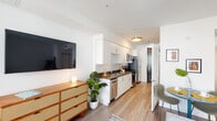 Located at 2525 Wilshire Boulevard in Los Angeles, CA, this thoughtfully designed single-floor residence offers a clean, modern aesthetic throughout. The open-concept layout connects the kitchen and living areas seamlessly, creating an efficient and inviting flow. The kitchen is outfitted with white flat-front cabinetry, dark stone countertops, and a full suite of stainless steel appliances — including a refrigerator, electric range, built-in microwave, and dishwasher — all set against a bright, white backdrop. Light wood-tone flooring runs throughout the space, adding warmth to the contemporary design. The living area is well-proportioned and benefits from natural light, with a sliding door providing access to a private balcony with city views. The bedroom is a calm, light-filled retreat featuring large windows that frame urban views and offer generous natural light. A full bathroom includes a tiled soaking tub with a subway tile surround, combining functionality with clean, modern styling. The overall ambiance of this residence is bright, contemporary, and well-appointed — ideally situated in the Westlake neighborhood with convenient access to the broader Los Angeles area.
