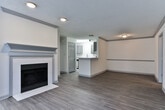 Located at 5300 SR-138 in Union City, Georgia, this single-floor residence offers a clean, modern interior designed for comfortable everyday living. The open-concept living and dining area is anchored by a classic fireplace with a painted mantle, wood-style plank flooring, and a textured ceiling that adds subtle character. A half-wall peninsula connects the living space to the kitchen, which is outfitted with grey shaker-style cabinetry, quartz countertops, a white subway tile backsplash, a stainless steel gas range, a dishwasher, and a pull-down faucet sink — a well-equipped space suited for both everyday cooking and entertaining. The bedrooms feature soft, neutral carpeting and are filled with natural light from multiple windows dressed with blinds. One bedroom benefits from a distinctive octagonal accent window, adding an architectural touch. The bathrooms are finished with wood-look tile flooring, white tile tub-shower surrounds, and grey vanity cabinetry that coordinates with the kitchen aesthetic. Throughout the residence, a consistent neutral color palette of whites and warm beiges creates a bright, inviting ambiance that is both versatile and move-in ready.