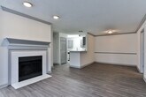 Located at 5300 SR-138 in Union City, Georgia, this single-floor residence offers a clean, modern interior designed for comfortable everyday living. The open-concept living and dining area is anchored by a classic fireplace with a painted mantle, wood-style plank flooring, and a textured ceiling that adds subtle character. A half-wall peninsula connects the living space to the kitchen, which is outfitted with grey shaker-style cabinetry, quartz countertops, a white subway tile backsplash, a stainless steel gas range, a dishwasher, and a pull-down faucet sink — a well-equipped space suited for both everyday cooking and entertaining. The bedrooms feature soft, neutral carpeting and are filled with natural light from multiple windows dressed with blinds. One bedroom benefits from a distinctive octagonal accent window, adding an architectural touch. The bathrooms are finished with wood-look tile flooring, white tile tub-shower surrounds, and grey vanity cabinetry that coordinates with the kitchen aesthetic. Throughout the residence, a consistent neutral color palette of whites and warm beiges creates a bright, inviting ambiance that is both versatile and move-in ready.
