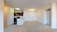 This single-floor residence offers three bedrooms and two full bathrooms within a thoughtfully designed open-concept layout. The living area is expansive, featuring neutral carpet flooring, track lighting, and a seamless connection to the kitchen, which is separated by a peninsula with a granite countertop and sink. The kitchen is well-equipped with dark espresso cabinetry, granite countertops, stainless steel appliances including a range, microwave, and dishwasher, and a classic white subway tile backsplash. Wood-style flooring runs throughout the kitchen and wet areas, providing a clean contrast to the carpeted living and sleeping spaces.

The bedrooms are generously sized, each featuring ceiling fans, neutral carpet, and windows that bring in natural light. The primary bedroom includes multiple windows and access to a closet. Both bathrooms are finished with dark vanity cabinetry, granite countertops, white subway tile tub surrounds, and wood-style flooring. A dedicated in-unit laundry room includes full-size side-by-side washer and dryer units alongside built-in shelving for added storage.