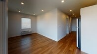 This single-floor unit at Swivel 545 in Omaha, Nebraska, offers a thoughtfully designed layout with modern finishes and practical amenities. The open living area features warm wood-style flooring, recessed lighting, and a sliding glass door that leads to a private balcony, allowing natural light to fill the space. The kitchen is equipped with stainless steel appliances—including a refrigerator, range, dishwasher, and over-the-range microwave—complemented by quartz countertops, white cabinetry with black hardware, and a bold dark tile backsplash that adds a contemporary contrast.

The bedroom is carpeted for comfort and includes a window with blinds and a wall-mounted HVAC unit for individual climate control. The bathroom features wood-style flooring, a white vanity with quartz countertops, black hardware accents, a tub-shower combination with a sliding glass enclosure, and a large mirror with globe lighting. A hallway houses a stacked washer and dryer unit, providing in-unit laundry convenience. Throughout the space, neutral tones, clean lines, and consistent finishes create a cohesive, modern ambiance suited for everyday living.