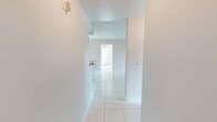 Located at 7575 Hampton Boulevard in North Lauderdale, Florida, this single-floor, 2-bedroom, 2-bathroom home offers a well-organized and functional layout. Light-toned tile flooring runs throughout the entire space, creating a clean, cohesive aesthetic that reflects natural and artificial light alike.

The galley-style kitchen is a standout feature, showcasing rich dark-espresso cabinetry, granite countertops, stainless steel appliances including an electric range, built-in microwave, and dishwasher, along with a deep sink — all flowing seamlessly into the adjacent dining area, which is accented by a chandelier overhead.

The living and dining areas are bright and open, with neutral walls and tile floors that maintain the home's airy feel. The primary bedroom is generously proportioned and includes access to a sliding glass door, offering additional natural light. Both bedrooms are served by closets with built-in wire shelving for organized storage.

The bathrooms feature tiled tub-shower combinations, granite-topped vanities, and clean, functional finishes. A dedicated laundry room houses a full-sized washer and dryer. The hallway connects all areas of the home smoothly, contributing to an efficient and comfortable floor plan ideal for everyday living.