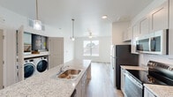 Located at 2817 Andover St in Jefferson, Louisiana, this single-floor, three-bedroom, two-bathroom home offers a thoughtfully designed layout with contemporary finishes throughout. Light hardwood-style flooring flows seamlessly across the entire space, creating a clean and cohesive aesthetic.

The kitchen serves as the heart of the home, anchored by a generous granite-topped island with an integrated sink and pendant lighting above. Gray shaker-style cabinetry pairs with a full suite of stainless steel appliances, including a refrigerator, range, microwave, and dishwasher. A dedicated in-unit laundry area is conveniently tucked nearby. The kitchen opens directly to a bright living area with a ceiling fan and a window that brings in natural light.

The bedrooms are bright and neutral, each featuring light-toned walls and hardwood-style flooring. The primary bedroom includes windows overlooking the surrounding neighborhood and ample space for furnishings. One bathroom features a walk-in shower with a granite-topped vanity, while the second includes a full tub-shower combination and a vanity with matching granite countertops. An adjacent walk-in closet with wire shelving provides practical storage. The home's clean, modern palette makes it a versatile and functional living space.