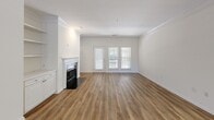 Located in Charlotte, NC, this single-story, 3-bedroom, 3-bathroom home offers a thoughtfully designed layout with wood-look flooring throughout and a clean, neutral color palette that creates a bright and welcoming atmosphere. The living room is a standout space, featuring crown molding, a classic white fireplace surround, and glass doors that invite natural light while providing outdoor access. The kitchen is well-appointed with white cabinetry, dark countertops, stainless steel appliances including a range, microwave, and refrigerator, plus a window above the sink. The spacious primary bedroom includes crown molding, a large window with outdoor views, and an en-suite bathroom with a white vanity, built-in drawers, and a large mirror. A walk-in closet with wire shelving provides generous storage. The additional bedrooms are comfortable and bright, each featuring ceiling fans and windows that bring in natural light. The bathrooms maintain a consistent, clean aesthetic with white finishes. A dedicated walk-in closet with built-in shelving adds practical storage. The attached garage features a durable concrete floor, completing this functional and well-maintained home.