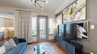 Located at Post Oak Park Drive in Houston's upscale 77027 corridor, this well-appointed one-bedroom, one-bathroom residence offers a thoughtfully designed single-floor layout with modern finishes throughout. The living room is bright and inviting, featuring wood-style flooring, a sleek sputnik chandelier, and French doors that open onto a private balcony, allowing natural light to fill the space. A bold accent wall with curated artwork adds a contemporary edge to the room's design.

The kitchen is efficiently laid out with light wood cabinetry, granite countertops, stainless steel appliances including a French door refrigerator and dishwasher, and a window that brings in additional natural light. Adjacent to the kitchen, the dining area connects seamlessly to the living space, with room for a full dining table and an open industrial shelving unit that adds character and storage.

The bedroom features a tray ceiling, a charcoal accent wall, large windows with natural light, and direct access to a spacious walk-in closet. The full bathroom is clean and well-finished, offering a granite-topped vanity with light wood cabinetry, a tiled soaking tub and shower combination, and tile flooring. A dedicated in-unit laundry closet with a full-size washer and dryer rounds out this functional and stylish residence.