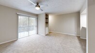 Located in Sandy Springs, GA, this well-appointed single-floor residence offers three bedrooms, two bathrooms, and a thoughtfully designed layout. The combined dining and living area serves as the heart of the home, featuring plush carpet, a ceiling fan with light fixture, and sliding glass doors that open to a private balcony with outdoor views, flooding the space with natural light. Built-in wall shelving adds both character and functionality to the living area.

The kitchen is efficiently designed with white cabinetry, granite countertops, stainless steel appliances including a refrigerator, range, and microwave, and light wood-style flooring. A peninsula counter connects the kitchen to the living space, creating an open and accessible flow.

The three carpeted bedrooms each include ceiling fans and windows for natural light. The primary bedroom offers generous proportions and balcony access via sliding glass doors. Both bathrooms feature tiled tub-shower combinations and granite-topped vanities.

Additional highlights include a dedicated pantry, laundry room, utility room, and an impressive five closets for ample storage throughout. The neutral color palette and consistent finishes create a cohesive, move-in ready environment.