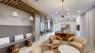 Located at 3521 Wilshire Way in Richardson, TX, this elegantly designed single-floor space offers a seamless blend of modern sophistication and refined comfort. The open layout encompasses a living room, dining room, and kitchen, each thoughtfully appointed with high-end finishes and curated details.

The living room is anchored by a wall-mounted flat-screen TV and features two plush sofas, a brass Sputnik chandelier, and textured wallcoverings in warm neutral tones. An adjoining lounge nook with built-in bench seating, gold accent stools, and pendant lighting provides an intimate retreat within the space.

The dining room is bathed in natural light from large windows dressed in mauve drapes, offering outdoor views of the surrounding neighborhood. A substantial wood dining table surrounded by upholstered chairs sits beneath a tray ceiling, with geometric-patterned wallcovering and framed artwork adding visual interest.

The kitchen is outfitted with dark wood cabinetry featuring brass hardware, white countertops, a stainless steel sink, and stainless steel appliances, all set against a subtle tile backsplash and large-format tile flooring that flows throughout the space.

Together, these rooms create a polished, cohesive environment defined by warm metallics, layered textures, and contemporary design sensibility.