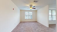 Located at 1405 Southwood Plantation Rd in Tallahassee, FL, this single-floor, 2-bedroom, 2-bathroom residence offers a well-organized and functional layout. The kitchen serves as a central highlight, featuring rich dark wood cabinetry, granite-style countertops, a peninsula island with a stainless steel sink, hardwood-style flooring, track lighting, and black appliances including a refrigerator, range, and microwave. The kitchen flows naturally into the adjacent living areas, creating an open and connected feel.

Both bedrooms are carpeted and filled with natural light through large windows with views of the surrounding greenery. Each room is equipped with a ceiling fan and offers a comfortable, well-proportioned footprint. The primary bedroom connects to a private bathroom and a walk-in closet outfitted with wire shelving systems for organized storage. A second walk-in closet provides additional storage elsewhere in the unit.

The bathrooms feature wood-style tile flooring, granite-topped dark wood vanities, and tiled shower and tub enclosures with glass doors. Clean, neutral tones throughout the residence create a cohesive and move-in-ready ambiance, making this a practical and comfortable home in the Southwood community.