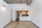 Located at 1080 Euclid Ave NE in Atlanta's vibrant Inman Park neighborhood, this single-floor unit blends industrial character with modern finishes throughout. The space showcases polished concrete floors that run through the main living and bedroom areas, lending an urban, loft-like aesthetic complemented by exposed concrete and raw masonry walls that highlight the building's original architectural bones.

The kitchen is a standout feature, outfitted with stainless steel appliances including a refrigerator, gas range, and built-in microwave. Crisp white cabinetry pairs with granite countertops and a dark subway tile backsplash, while exposed brick accents along the upper wall add warmth and texture. A built-in shelving niche with a concrete surround provides additional storage and visual interest.

The bedroom areas benefit from high ceilings and windows that draw in natural light, with one room featuring a clerestory window that enhances the sense of vertical space. The exposed concrete accent walls carry the industrial theme seamlessly into the living spaces.

The bathroom is cleanly appointed with a full tub-and-shower combo, chrome fixtures, and wood-look flooring that softens the overall aesthetic. Throughout the unit, the contrast between raw industrial surfaces and refined finishes creates a distinctive and characterful living environment.