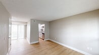 Located at 1251 N Ardenwood Dr in Baton Rouge, Louisiana, this two-bedroom, one-bathroom residence offers a thoughtfully arranged single-floor layout. Light wood-style flooring runs throughout the space, complemented by warm neutral-toned walls and crisp white trim, creating a clean and cohesive aesthetic.

The living room features a textured ceiling, a ceiling fan with light fixture, and a window fitted with blinds that allows natural light to filter in. The galley-style kitchen is well-appointed with white cabinetry, granite-look countertops, a stainless steel over-the-range microwave, and an electric range, providing efficient use of the available space.

Both bedrooms are comfortably sized, each equipped with ceiling fans and windows that bring in natural light. The primary bedroom is notably spacious and includes a dedicated closet. The second bedroom features louvered bifold closet doors, offering practical storage. A walk-in style closet with built-in shelving and a hanging rod provides additional storage options.

The bathroom includes a full tub-shower combination with clean white surround. Two hallways connect the rooms efficiently, and the overall layout, as seen in the dollhouse view, is compact yet functional. Textured ceilings are consistent throughout the unit.