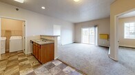 Located at 1601 Belsly Blvd in Moorhead, MN, this well-appointed two-bedroom, two-bathroom unit offers a comfortable and practical single-floor layout. The open-concept kitchen features warm wood cabinetry, a tile floor in a classic checkered pattern, stainless steel refrigerator, microwave, and a peninsula with a double sink that flows naturally into the carpeted living area. The living room is bright and inviting, highlighted by a sliding glass door that lets in natural light and provides access to an outdoor view. Both bedrooms are generously sized and finished with soft carpet flooring. The spacious primary bedroom includes a walk-in closet outfitted with wire shelving, offering ample storage. Each bedroom benefits from large windows that bring in additional natural light. The two full bathrooms are finished with tile flooring and warm-toned vanities, each including a full tub-shower combination. A dedicated in-unit laundry room with full-size washer and dryer adds everyday convenience. Throughout the unit, neutral wall tones and textured ceilings create a clean, consistent aesthetic. This thoughtfully designed unit provides a functional and comfortable living experience in a residential Moorhead location.