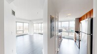 Located on the 16th floor at 180 Brookline Ave in Boston's Fenway neighborhood, this two-bedroom, two-bathroom residence offers an elevated urban living experience with sweeping panoramic views of the Boston skyline. The open-concept living and dining area is bathed in natural light through expansive floor-to-ceiling windows, showcasing hardwood flooring and a clean, modern aesthetic throughout.

The galley-style kitchen is well-appointed with warm wood cabinetry, dark granite countertops, stainless steel appliances including a refrigerator, range, microwave, and dishwasher, and a large window framing striking city views — making it as functional as it is visually impressive.

The spacious primary bedroom features large windows that continue the home's connection to the surrounding cityscape, while neutral tones and hardwood floors create a calm, restful atmosphere. The second bedroom offers similar design continuity and generous proportions. Both bathrooms are thoughtfully finished; one features a glass-enclosed walk-in shower, dark accent walls, built-in shelving, and a wood-toned vanity with granite countertops.

A dedicated laundry area with a full-size washer and dryer adds everyday convenience. The residence combines contemporary finishes with high-floor living, delivering a sophisticated and functional home in the heart of Boston.