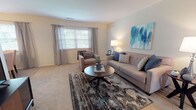 Located at 744 Eayrestown Rd in Lumberton, New Jersey, this single-floor residence offers a well-organized and functional layout with comfortable living spaces throughout. The living room is bright and inviting, featuring plush carpeting, a large window with draping curtains that allow natural light to fill the room, and ample space for seating. Adjacent to the living area is a dedicated dining space, finished with hard-surface flooring and a classic chandelier overhead, alongside a window that adds to the room's natural brightness. The kitchen is efficiently laid out in an L-shape, featuring white cabinetry, light countertops, and full appliances including a refrigerator, electric range, and dishwasher. The bedroom is generously sized with soft carpeting, a large window, and a sliding-door closet, providing comfortable and practical accommodations. A hallway bathroom includes tile flooring, a single-sink vanity with a large mirror, and direct access to the main living area. Throughout the residence, warm neutral tones on the walls and light-colored carpeting create a cohesive and welcoming ambiance, making this a well-appointed and move-in ready home.