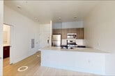 Located at 280 Fairmount Ave in Jersey City, NJ, this well-appointed one-bedroom, one-bathroom residence offers a thoughtfully designed layout with modern finishes throughout. The open-concept kitchen and living area serves as the heart of the home, featuring light wood-style flooring, crisp white walls, and soaring ceilings that enhance the sense of space. The kitchen is equipped with stainless steel appliances—including a full-size refrigerator, gas range, and built-in microwave—complemented by wood-toned cabinetry, a quartz countertop peninsula with an undermount sink, and a matte black faucet. A subway tile backsplash adds a clean, contemporary touch. Large black-framed windows flood the living area with natural light and offer open views of the surrounding Jersey City neighborhood. The bedroom continues the light flooring and neutral palette, with a generous black-framed window that brings in ample daylight and urban views. Three closets provide excellent storage throughout the unit. The bathroom features a wood-toned vanity with a quartz countertop, an undermount sink, a large mirror, and a glass-enclosed walk-in shower with mosaic tile flooring. An in-unit laundry area adds everyday convenience, completing this modern and functional residence.
