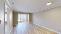 Located at 1001 Riverland Woods Pl in Charleston, SC, this single-level, one-bedroom, two-bathroom residence offers a thoughtfully designed layout with consistent light hardwood flooring throughout. A welcoming entry hallway with crown molding leads into the open-concept kitchen and living area. The kitchen is well-appointed with white shaker-style cabinetry, granite countertops, a peninsula with an undermount sink, and a full suite of stainless steel appliances including a refrigerator, electric range, microwave, and dishwasher. Crown molding accents the kitchen ceiling, adding a refined touch. The living room is bright and open, featuring large windows that invite abundant natural light and views of the surrounding greenery. The spacious primary bedroom includes a ceiling fan, a generous window overlooking the exterior, and access to a dedicated closet. Both bathrooms are finished with hardwood-style flooring, granite-topped vanities with white cabinetry, and tub-shower combinations. Neutral warm-beige walls and clean white trim unify the space throughout, creating a cohesive and move-in-ready atmosphere well-suited to comfortable everyday living in the Charleston area.