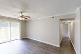 Located at 4321 NW University Dr in Huntsville, Alabama, this single-floor, 2-bedroom, 2-bathroom unit offers a practical and well-organized layout. The combined living and dining area serves as the heart of the home, featuring dark hardwood-style flooring, crown molding, a textured ceiling, and a ceiling fan with light fixture. A sliding glass door floods the space with natural light and provides outdoor access, while vertical blinds offer privacy. An entry door is also situated within this open area.

The galley-style kitchen is efficiently designed with gray cabinetry, laminate countertops, a stainless steel double sink, tile flooring, and black appliances including a refrigerator and range, all framed by crown molding for a clean finish.

Both bedrooms feature plush carpeting, ceiling fans, crown molding, and windows that bring in natural light. The spacious primary bedroom offers ample room for furnishings. Three closets throughout the unit provide generous storage.

The two bathrooms include tile flooring and full tub/shower combinations with white tile surrounds and granite-style vanity countertops. A hallway connects the bedrooms and bathrooms, completing this functional and comfortable floor plan.