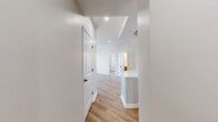 This contemporary apartment in Delancey at Shirlington Village offers 740 square feet of thoughtfully designed living space. The open floor plan features two bedrooms, including a primary bedroom of 130 square feet, and one full bathroom. The heart of the home is the combined kitchen and living area, showcasing a modern kitchen with wooden cabinetry, stainless steel appliances, and a convenient breakfast bar.

Throughout the apartment, warm wood flooring creates a cohesive and inviting ambiance. Large windows in the living areas and bedrooms flood the space with natural light and offer views of the surrounding area. The bathroom is fitted with modern fixtures and a combined tub and shower.

The apartment's neutral color palette provides a blank canvas for personalization. A closet in the entryway offers additional storage space. The overall design emphasizes functionality and comfort, making efficient use of the available square footage. This apartment is ideal for those seeking a contemporary living space in a vibrant community setting.