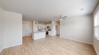 Located at 19815 Kenswick Drive in Humble, Texas, this single-story home showcases a clean, contemporary design with a bright and airy open-concept floor plan. Light wood-look flooring flows seamlessly throughout the living areas, complementing the neutral color palette and recessed lighting overhead.

The kitchen serves as the heart of the home, featuring a central island with a granite countertop and undermount sink, crisp white cabinetry, and a full suite of stainless steel appliances including a refrigerator with ice maker, electric range, built-in microwave, and dishwasher. The kitchen opens directly into the spacious living area, which is illuminated by natural light streaming through multiple windows and kept comfortable by a ceiling fan.

The living space is generously proportioned, offering an open and versatile layout ideal for a variety of uses. Windows along the exterior walls frame views of the surrounding neighborhood and allow ample daylight to fill the room.

The bathroom is well-appointed with a wide granite-topped double vanity, white cabinetry with brushed hardware, a large mirror, and contemporary lighting fixtures. Tall ceilings in the bathroom add a sense of openness. Throughout the home, finishes are consistent and modern, creating a cohesive and move-in ready environment.