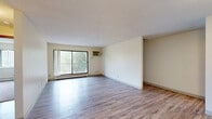 Located at 5200 W 98th St in Bloomington, MN, this two-bedroom, two-bathroom residence offers a well-organized single-floor layout designed for everyday comfort. The spacious living room greets you with light hardwood-style flooring, neutral walls, a textured ceiling, and a large sliding glass door that opens to a private balcony with outdoor views — allowing natural light to fill the room. An adjacent open area connects seamlessly to the entry hallway, enhancing the sense of openness throughout. The kitchen is outfitted with warm oak cabinetry, ample counter space, and white appliances including an electric range and over-the-range microwave, all complemented by matching hardwood-style flooring. Both bedrooms are carpeted and generously sized, each featuring wide windows with vertical blinds that invite natural light and outdoor views. The primary bedroom includes a sliding wood-panel closet, providing practical storage. The bathrooms are clean and functional, with one featuring a full tiled tub-and-shower combination with neutral beige tile surround. A vanity with wood cabinetry and a countertop mirror is tucked along the hallway corridor. Two hallways connect the rooms efficiently, rounding out this comfortable and well-appointed Bloomington residence.