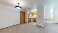 Located at 321 Highland Park Ave in Green Bay, Wisconsin, this single-floor unit offers a practical and well-organized layout designed for comfortable everyday living. The entry area opens directly to a carpeted living space with a pendant light fixture overhead and a view into the kitchen, creating an open and connected feel.

The kitchen is efficiently arranged with warm oak cabinetry, white laminate countertops, a double-basin stainless steel sink, and white appliances including a range, over-the-range microwave, refrigerator, and dishwasher. Overhead and base cabinets provide ample storage throughout.

A separate living room features soft carpet, a ceiling fan with light, a framed fireplace with a white mantel surround, and a window offering outdoor views. An additional carpeted room opens to the outdoors through sliding glass doors, providing direct access to a green exterior setting and filling the space with natural light.

Two bathrooms serve the unit. One includes a tub/shower combination, oak vanity with white countertop, and tile flooring. The second features a sliding glass-door shower enclosure, tile flooring, and a wall-mounted oak medicine cabinet. Both bathrooms maintain a clean, neutral aesthetic consistent with the rest of the unit.