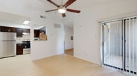 Located at 19200 Lyndon B Johnson Fwy in Mesquite, TX, this single-floor unit offers a well-organized layout that maximizes every square foot. The living room is bright and open, featuring light wood-style flooring, soaring vaulted ceilings, and a ceiling fan that enhances airflow and comfort. Large sliding glass doors lead to a private patio, allowing natural light to pour in while providing outdoor access. A pass-through window connects the living area to the kitchen, creating an open, connected feel. The kitchen is well-appointed with rich dark cabinetry, granite-style countertops, stainless steel appliances including a full-size refrigerator and electric range, and light tile flooring. The bedroom is carpeted for warmth and comfort, features its own ceiling fan, and includes convenient access to a full bathroom. A second bathroom serves additional needs within the unit. Two closets provide practical storage solutions throughout the space. The interior maintains a clean, neutral color palette of crisp white walls and light flooring throughout, creating a bright and airy ambiance. Overall, the unit delivers a functional and comfortable living environment with thoughtful design details.