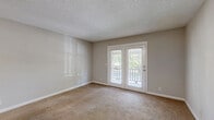 Located at 118 E Kingwood Dr in Murfreesboro, Tennessee, this single-floor, one-bedroom, one-bathroom residence offers a well-organized and functional layout. The combined kitchen and living area forms the heart of the home, with the kitchen showcasing white shaker-style cabinetry, light granite-look countertops, stainless steel appliances including a refrigerator and range, and light wood-look flooring that adds a clean, modern touch. The open layout flows seamlessly into the living room, which features neutral carpet, soft neutral-toned walls, and a textured ceiling. A standout feature of the living room is a set of French doors that open onto a private outdoor balcony, allowing natural light to fill the space and providing pleasant outdoor views. The bedroom is a comfortable, well-lit room with plush carpet, a window overlooking greenery, and a bifold-door closet, with direct access to the full bathroom. The bathroom is equipped with a full tub-and-shower combination with built-in shelving. A hallway connects the main living spaces, and the entry area transitions between the hard-surface flooring of the kitchen and the carpeted living zone. The unit offers a practical and inviting living environment throughout.