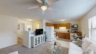 Located at 108 Brownlea Dr in Greenville, NC, this single-floor, three-bedroom, one-bathroom unit offers a practical and comfortable layout. The open-concept living and kitchen area serves as the heart of the home, with carpet flooring in the living room, a ceiling fan with light fixture, and a textured ceiling. The kitchen is well-equipped with warm oak cabinetry, a double stainless steel sink, white appliances including a refrigerator, electric range, and dishwasher, plus tile flooring and ample counter space.

The living room provides a welcoming atmosphere with natural light from a window and direct access to multiple rooms. Three carpeted bedrooms offer restful retreats, each featuring closets with wire shelving for storage. The primary bedroom includes a distinctive teal accent door and direct access to a utility area housing a full-size washer and dryer — a convenient in-unit amenity.

The shared bathroom is clean and functional, featuring a tub-shower combination, a single-sink vanity with a wood cabinet, and tile flooring. Throughout the unit, neutral tones, textured ceilings, and carpeted floors create a cohesive, low-maintenance environment suited for comfortable everyday living.
