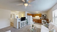 Located at 108 Brownlea Dr in Greenville, NC, this single-floor, three-bedroom, one-bathroom unit offers a practical and comfortable layout. The open-concept living and kitchen area serves as the heart of the home, with carpet flooring in the living room, a ceiling fan with light fixture, and a textured ceiling. The kitchen is well-equipped with warm oak cabinetry, a double stainless steel sink, white appliances including a refrigerator, electric range, and dishwasher, plus tile flooring and ample counter space.

The living room provides a welcoming atmosphere with natural light from a window and direct access to multiple rooms. Three carpeted bedrooms offer restful retreats, each featuring closets with wire shelving for storage. The primary bedroom includes a distinctive teal accent door and direct access to a utility area housing a full-size washer and dryer — a convenient in-unit amenity.

The shared bathroom is clean and functional, featuring a tub-shower combination, a single-sink vanity with a wood cabinet, and tile flooring. Throughout the unit, neutral tones, textured ceilings, and carpeted floors create a cohesive, low-maintenance environment suited for comfortable everyday living.