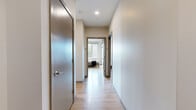 Located at 525 Lincoln St in Boston's Allston neighborhood, this well-appointed residence offers four bedrooms and three bathrooms across a single thoughtfully designed floor. Light hardwood flooring runs throughout, complemented by neutral warm-toned walls that create a cohesive, modern aesthetic.

The open-concept kitchen and living area serves as the heart of the home. The kitchen features warm wood cabinetry, stainless steel appliances, a white subway tile backsplash, and a central island with seating — ideal for casual dining. The adjacent living room is bathed in natural light from oversized windows offering views of the surrounding Boston streetscape and tree-lined scenery.

A clean hallway connects the bedrooms, each featuring light hardwood floors, natural light from individual windows, and ample space. The spacious primary bedroom provides a comfortable retreat, while the additional bedrooms are well-suited for guests or a home office setup.

The three bathrooms are finished with sleek grey tile flooring and white rectangular wall tiles. Two bathrooms include glass-enclosed walk-in showers, while a third offers a full soaking tub. Together, they deliver a polished, hotel-like feel. The overall design balances modern functionality with a clean, inviting ambiance throughout.