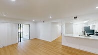 Located in Sunrise, FL, this 2-bedroom, 2-bathroom unit offers a thoughtfully designed single-level layout with a clean, modern aesthetic throughout. Light wood laminate flooring flows seamlessly across all living spaces, complementing crisp white walls and recessed lighting that keep the interior feeling bright and open.

The living areas are spacious and versatile, with multiple living zones providing flexibility for various configurations. Sliding glass doors with vertical blinds allow natural light to filter in while offering access to an outdoor area. The kitchen features white shaker cabinetry, light stone countertops, and stainless steel appliances, including a full-size refrigerator, with a bi-fold door providing convenient pantry storage.

Both bedrooms are well-proportioned and finished with the same warm wood flooring and white walls. The primary bedroom offers a generous footprint with a closet, while the second bedroom includes its own closet and recessed lighting. A hallway with louvered closet doors connects the bedroom wing to the rest of the unit.

The two bathrooms are cleanly finished with large-format white tile. One features an open walk-in shower with brushed gold fixtures, while the second includes a full soaking tub with a tile surround and matching gold hardware, providing a spa-like feel. The overall ambiance is minimal, fresh, and move-in ready.