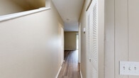 This two-floor residential space offers a functional and well-organized layout designed for comfortable everyday living. The main living area features durable wood-look flooring and is filled with natural light, thanks to a large sliding glass door that opens to outdoor views and a separate window with sheer curtains, creating an airy, open atmosphere with warm, neutral-toned walls throughout.

The galley-style kitchen is equipped with warm wood cabinetry, light stone-patterned countertops, a built-in sink, a gas range, and a full-size refrigerator. The layout maximizes efficiency while providing ample storage. An adjoining dining or flex area with matching flooring connects seamlessly to the kitchen.

A hallway with wood-look flooring and a louvered closet door leads to the private sleeping quarters, each finished with plush wall-to-wall carpeting and neutral walls. The bedrooms are well-sized, with windows that bring in natural light and outdoor views. Closet access is provided in the bedroom areas.

The bathrooms are clean and bright, featuring white cabinetry with stone-patterned countertops, single basin sinks, and light wood-look flooring. One bathroom includes a full tub-shower combination with a chrome fixtures and a curtain rod, while another features a vanity with a well-lit mirror. The overall aesthetic is clean, neutral, and move-in ready.