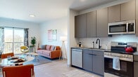 Located at 1851 Brevier Avenue in Cleveland's 44113 zip code, this one-bedroom, one-bathroom residence offers a thoughtfully designed single-floor layout with modern finishes throughout. Light wood-tone flooring flows seamlessly across every room, tying the space together with a clean, contemporary aesthetic.

The open-concept kitchen is outfitted with sleek grey cabinetry, a white subway tile backsplash, stainless steel appliances including a refrigerator, dishwasher, and range, and a deep single-basin sink — offering both style and functionality. A cozy dining nook sits just adjacent, perfect for everyday meals.

The living room is bright and inviting, benefiting from a large sliding glass door that opens to a private balcony with views of the surrounding neighborhood, allowing ample natural light to fill the space.

The bedroom is a serene retreat with a window overlooking the outdoors and direct access to a dedicated closet. A second closet provides additional storage convenience. An in-unit laundry area adds everyday practicality.

The bathroom features a taupe vanity with a white countertop, light wood-tone flooring, and clean white walls. The overall ambiance of this residence is modern, bright, and efficiently organized — ideal for comfortable urban living in Cleveland.