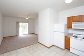 This single-floor unit offers a well-organized layout designed for comfortable everyday living. The open living area features plush carpeting, a ceiling fan, and a sliding glass door that fills the space with natural light while providing direct access to an outdoor balcony with exterior views.

Adjacent to the living area, the kitchen is outfitted with warm honey-toned wood cabinetry, ample upper and lower storage, light countertops, and a full suite of white appliances including a range, microwave, dishwasher, and refrigerator. The tile flooring transitions seamlessly from the kitchen into a convenient in-unit laundry closet tucked nearby, keeping household essentials centrally accessible.

The bedrooms are carpeted and bright, each featuring ceiling fans and windows that bring in natural daylight. One bedroom benefits from dual windows and outdoor views, while another offers a more intimate setting with a single window.

Two bathrooms serve the unit. One includes a single-sink vanity with wood cabinetry, a large mirror with vanity lighting, a walk-in shower, and tile flooring. The second bathroom features a soaking tub with a shower, tile flooring, and an adjacent closet area, providing additional storage.