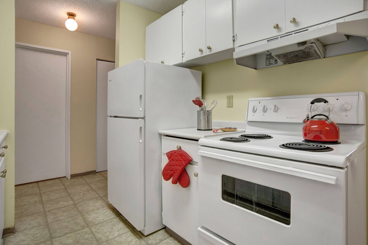 A kitchen with white appliances and white cabinetry - Tamaron Square