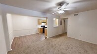 Located at 950 Military Rd in Jacksonville, Arkansas, this single-floor, one-bedroom, one-bathroom home offers a practical and comfortable layout. The combined kitchen and living area anchors the space, with the galley-style kitchen featuring warm honey-oak cabinetry on both sides, white countertops, a double stainless steel sink, and black appliances including a range with overhead exhaust and a refrigerator. Light wood-style flooring runs throughout the kitchen, providing a clean, easy-to-maintain surface. The living room is carpeted and bathed in natural light through a large window overlooking greenery outside, and a ceiling fan with a light fixture adds both comfort and ambiance. A convenient pass-through opening connects the living room to the kitchen area. The bedroom is a comfortable size, featuring plush carpet, a ceiling fan, and a window that allows in natural light and outdoor views. A closet provides dedicated storage. The bathroom is well-appointed with warm wood cabinetry, overhead storage, a full-size tub and shower combination, and matching wood-toned flooring. A hallway connects the main areas efficiently, completing this thoughtfully organized and functional home.