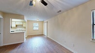 Located at 3113 Cherokee Ave in Columbus, Georgia, this single-floor, one-bedroom, one-bathroom home offers a practical and well-organized layout across a compact but efficient footprint. The combined kitchen and living room serves as the heart of the home, featuring warm hardwood-style flooring, neutral cream-toned walls, and a ceiling fan with light fixture. Natural light filters in through a window with blinds, creating a bright and welcoming atmosphere. A sliding panel door provides access to an adjacent area, adding functional versatility to the living space. The kitchen is designed for efficiency, with white cabinetry accented by wood trim, a double-basin sink, a dishwasher, a refrigerator, and an electric range — all arranged in a galley-style configuration along hardwood-style flooring. The bedroom offers a comfortable, carpeted retreat equipped with a ceiling fan and a window that invites natural light. A dedicated closet provides added storage. The bathroom features tile flooring, a vanity with a sink, a toilet, and a window that enhances ventilation and brightness. A hallway connects the rooms cohesively, completing this straightforward and move-in ready home.